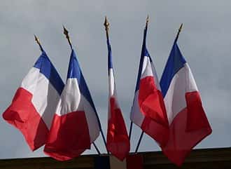 Multiple French flags as commonly flown from public buildings.